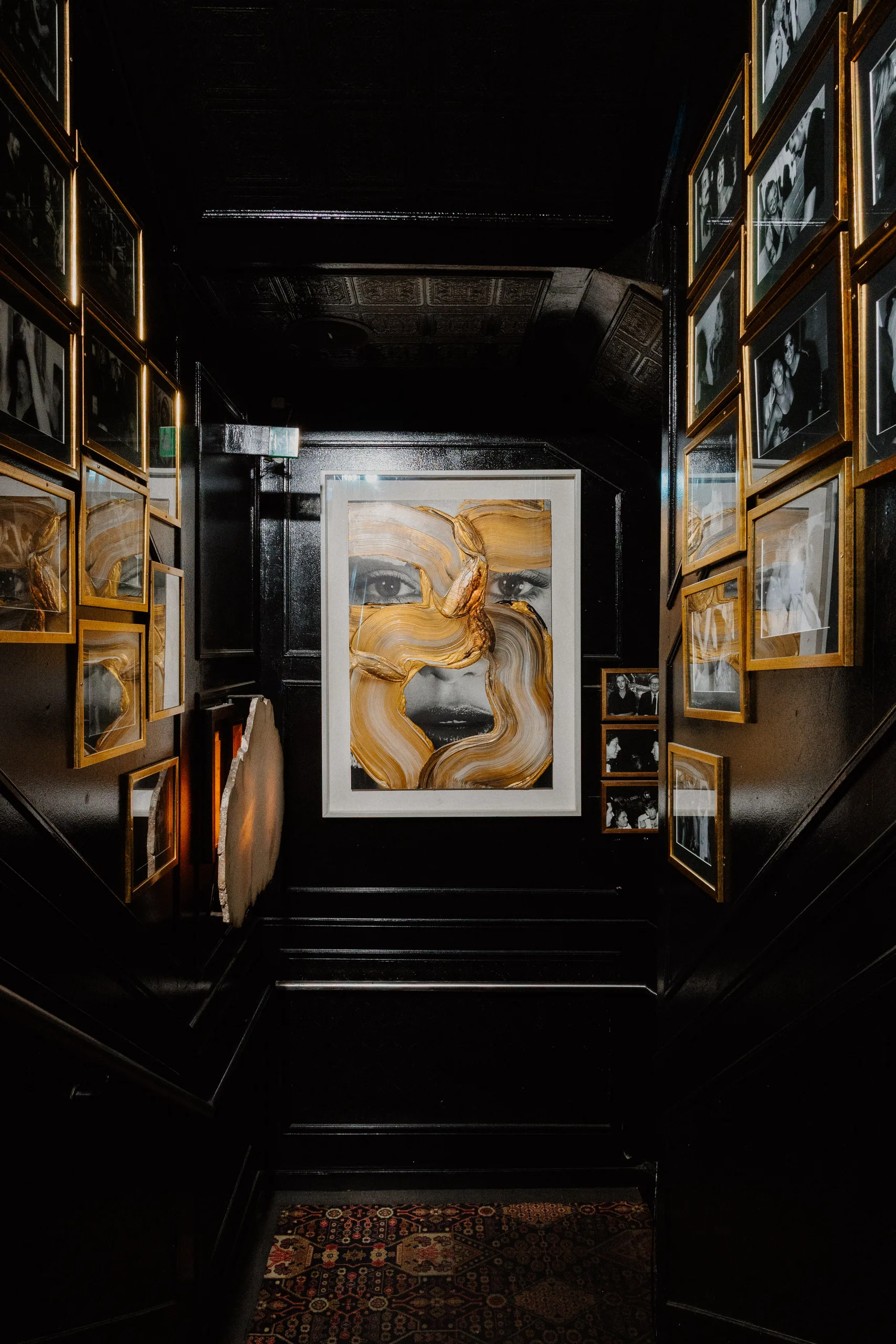 Gold-painted portrait in the black gallery hallway